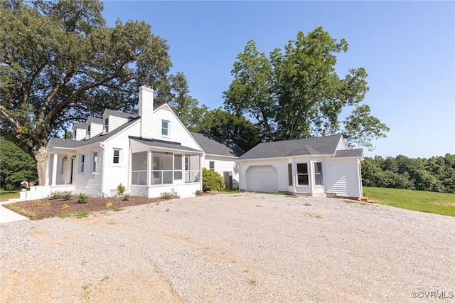 4700 New Kent, Quinton, VA 23141 - view of front of house featuring dirt driveway, a sunroom, a chimney, an attached garage, and an outdoor structure