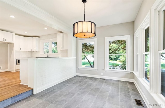 4700 New Kent, Quinton, VA 23141 - kitchen featuring white cabinetry, light countertops, backsplash, decorative light fixtures, and a peninsula