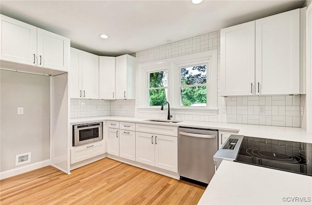 4700 New Kent, Quinton, VA 23141 - kitchen with appliances with stainless steel finishes, light countertops, white cabinetry, light wood-style floors, and tasteful backsplash