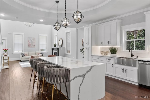 208 Minor St, Richmond, VA 23222 - kitchen with stainless steel dishwasher, a center island, open floor plan, light stone counters, and white cabinetry