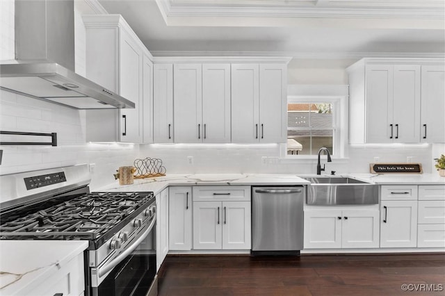 210 Minor St, Richmond, VA 23222 - kitchen featuring stainless steel appliances, wall chimney range hood, ornamental molding, white cabinets, and dark wood-style flooring