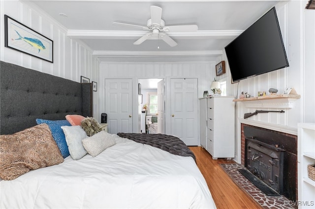 3942 Hickory Rd, Richmond, VA 23235 - bedroom featuring light wood-type flooring, crown molding, a wood stove, and a ceiling fan
