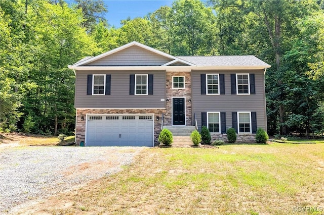 344 Land Or Dr, Ruther Glen, VA 22546 - bi-level home with gravel driveway, stone siding, a front lawn, and a garage