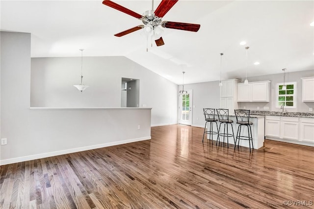 344 Land Or Dr, Ruther Glen, VA 22546 - unfurnished living room featuring healthy amount of natural light, a ceiling fan, vaulted ceiling, wood finished floors, and recessed lighting