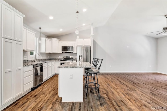344 Land Or Dr, Ruther Glen, VA 22546 - kitchen with stainless steel appliances, a breakfast bar, vaulted ceiling, white cabinets, and dark wood-style flooring