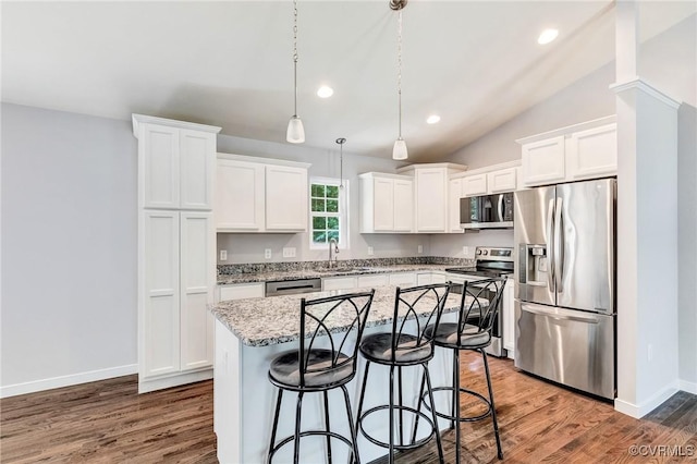 344 Land Or Dr, Ruther Glen, VA 22546 - kitchen with appliances with stainless steel finishes, white cabinetry, a kitchen island, wood finished floors, and a kitchen bar