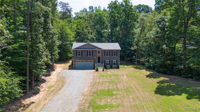 344 Land Or Dr, Ruther Glen, VA 22546 - bi-level home with dirt driveway, a garage, a forest view, and a front lawn