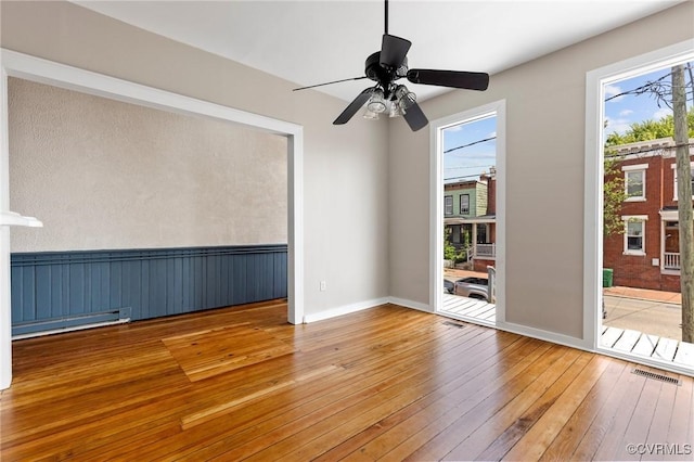 20 S Lombardy St, Richmond, VA 23220 - empty room featuring hardwood / wood-style floors, baseboard heating, ceiling fan, and a wainscoted wall