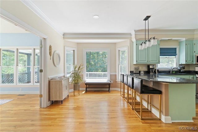 3608 Tyverton Ct, Henrico, VA 23233 - kitchen featuring light wood-style flooring, crown molding, a breakfast bar area, a peninsula, and pendant lighting