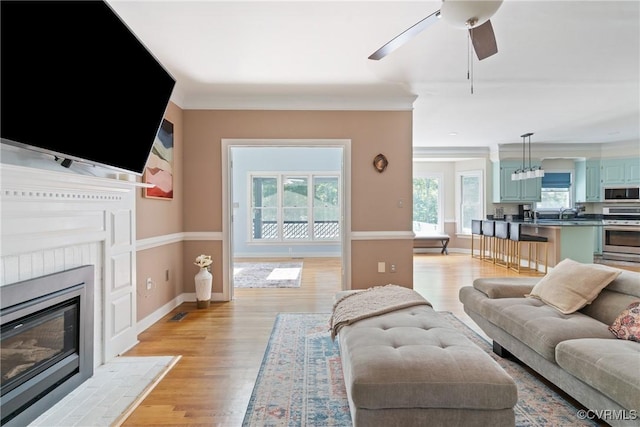 3608 Tyverton Ct, Henrico, VA 23233 - living area with a ceiling fan, a fireplace with flush hearth, light wood-style floors, and ornamental molding