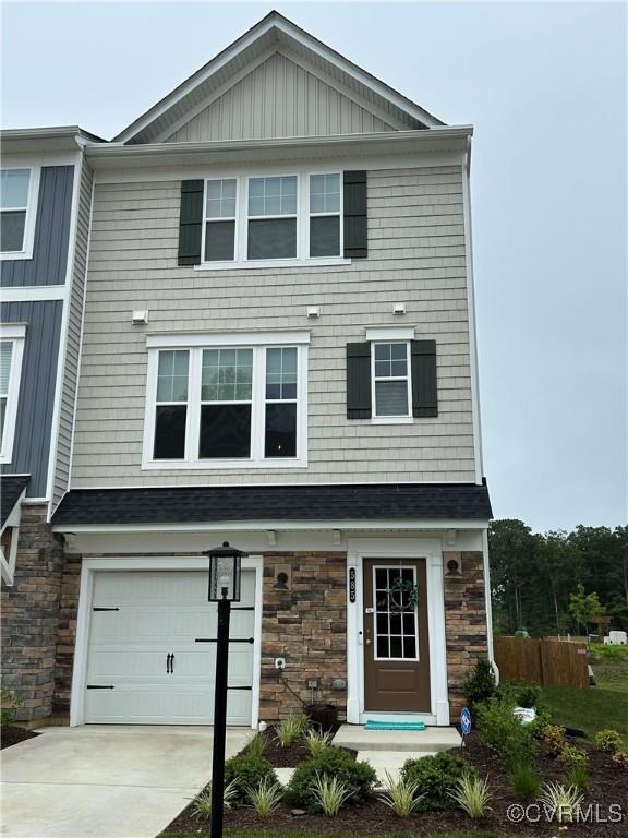 585 Rivanna Hill Rd, Glen Allen, VA 23060 - view of front of house with stone siding, an attached garage, concrete driveway, and board and batten siding