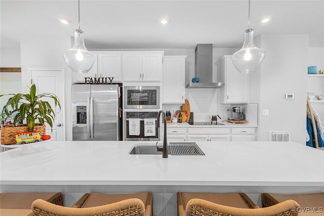 585 Rivanna Hill Rd, Glen Allen, VA 23060 - kitchen featuring appliances with stainless steel finishes, wall chimney exhaust hood, a breakfast bar, hanging light fixtures, and recessed lighting