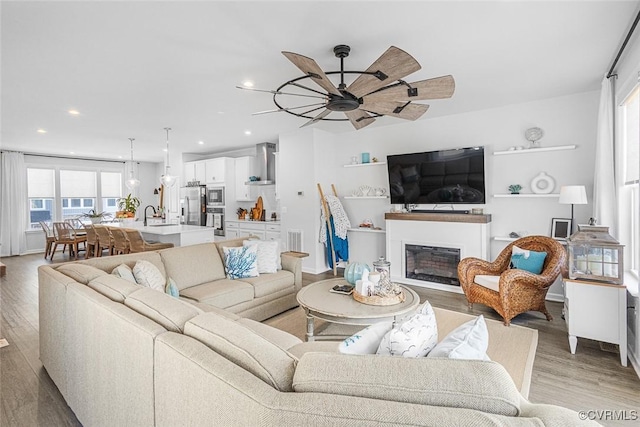585 Rivanna Hill Rd, Glen Allen, VA 23060 - living room featuring light wood finished floors, ceiling fan, a glass covered fireplace, and recessed lighting