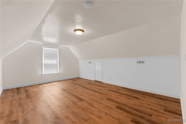 102 Penrith Ct, Williamsburg, VA 23185 - additional living space featuring wood finished floors, vaulted ceiling, and a wainscoted wall