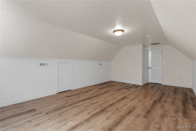 102 Penrith Ct, Williamsburg, VA 23185 - additional living space featuring wood finished floors, vaulted ceiling, and a wainscoted wall