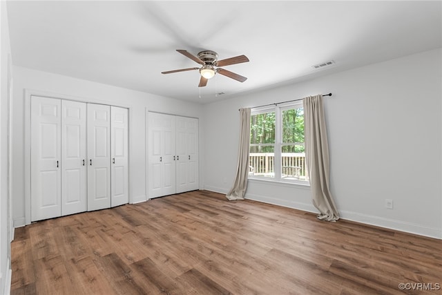 102 Penrith Ct, Williamsburg, VA 23185 - unfurnished bedroom with wood finished floors, two closets, and a ceiling fan