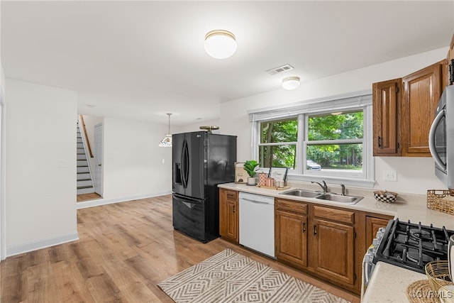 102 Penrith Ct, Williamsburg, VA 23185 - kitchen with dishwasher, black fridge with ice dispenser, light countertops, brown cabinets, and stainless steel microwave