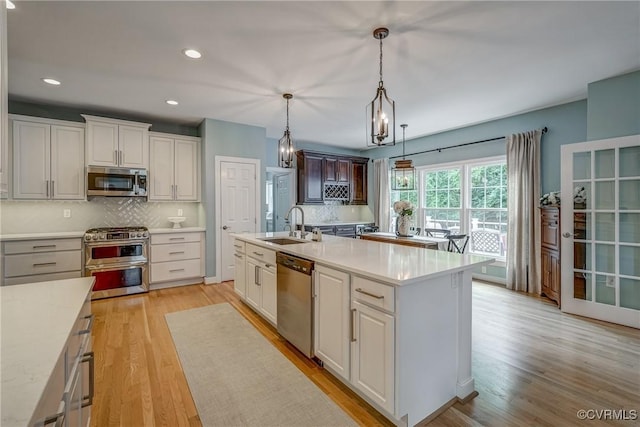 3731 Rivermist Ter, Midlothian, VA 23113 - kitchen featuring appliances with stainless steel finishes, light countertops, tasteful backsplash, light wood-style flooring, and recessed lighting