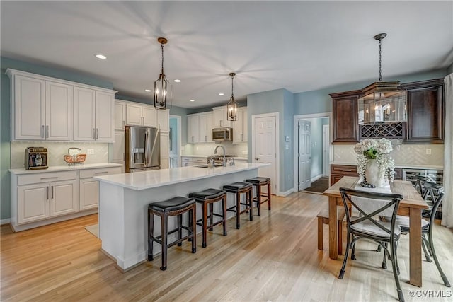 3731 Rivermist Ter, Midlothian, VA 23113 - kitchen featuring appliances with stainless steel finishes, light countertops, a kitchen bar, tasteful backsplash, and recessed lighting
