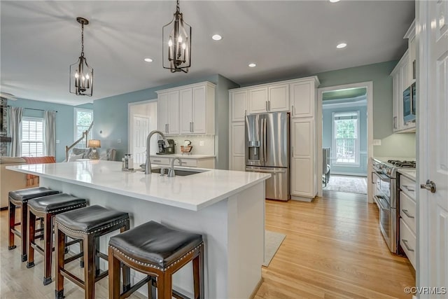 3731 Rivermist Ter, Midlothian, VA 23113 - kitchen featuring appliances with stainless steel finishes, a kitchen bar, a chandelier, decorative light fixtures, and light countertops