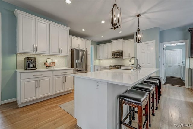 3731 Rivermist Ter, Midlothian, VA 23113 - kitchen with light wood-style flooring, stainless steel appliances, white cabinetry, backsplash, and recessed lighting