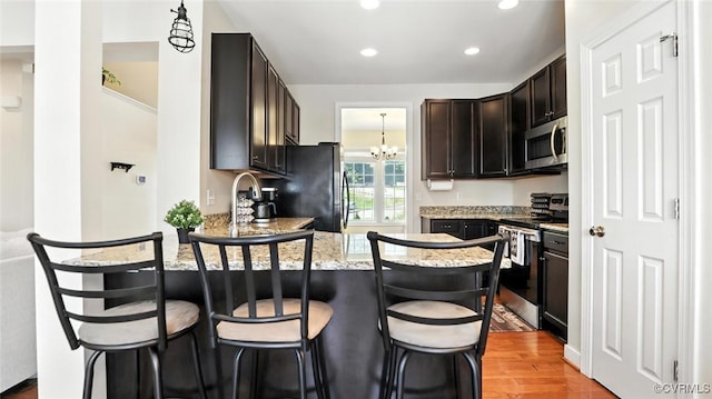 3809 Crows Nest Ct, Hopewell, VA 23860 - kitchen with stainless steel appliances, a peninsula, a chandelier, recessed lighting, and dark brown cabinetry
