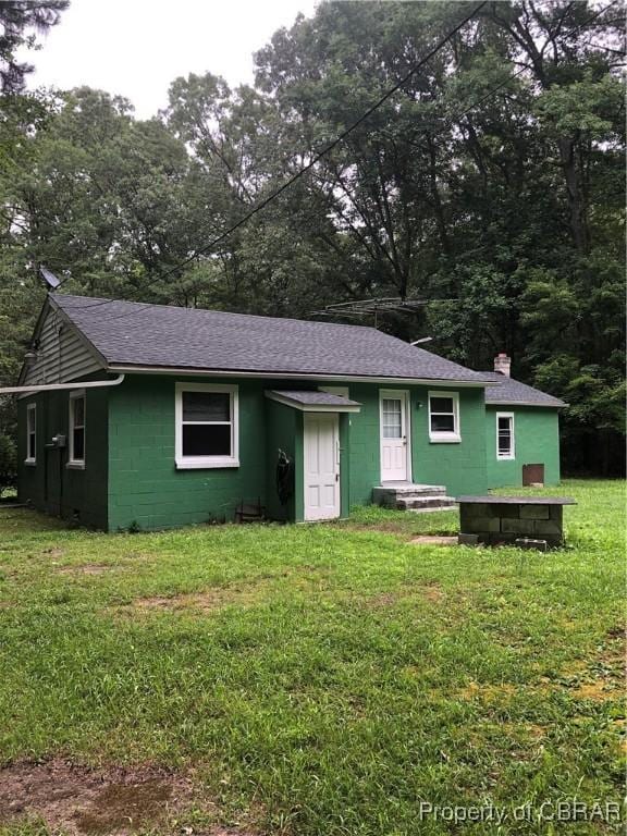 271 Bendall Ln, Mathews, VA 23109 - view of front of property featuring concrete block siding, roof with shingles, a front lawn, and a chimney