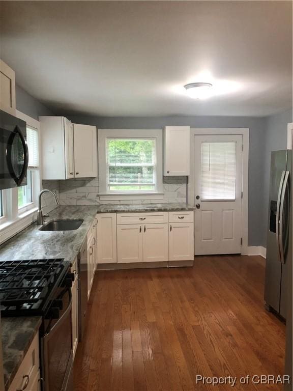 271 Bendall Ln, Mathews, VA 23109 - kitchen with appliances with stainless steel finishes, dark wood-style flooring, backsplash, and white cabinetry