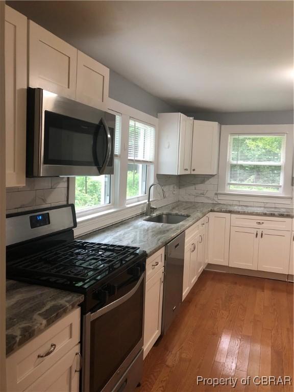 271 Bendall Ln, Mathews, VA 23109 - kitchen featuring appliances with stainless steel finishes, plenty of natural light, light stone counters, and dark wood-style flooring