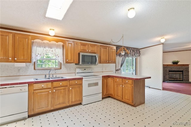 4867 Tabscott Rd, Kents Store, VA 23084 - kitchen featuring white appliances, a peninsula, a textured ceiling, a fireplace, and light floors