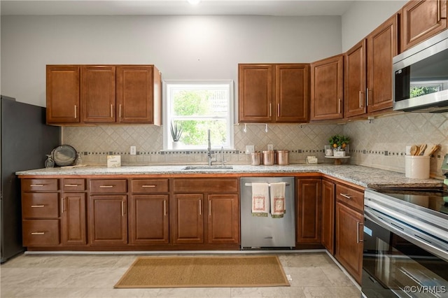 2502 4th Ave, Richmond, VA 23222 - kitchen featuring stainless steel appliances, brown cabinetry, and tasteful backsplash