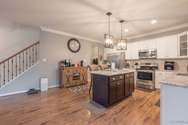 9545 Thornecrest Dr, Mechanicsville, VA 23116 - kitchen featuring appliances with stainless steel finishes, crown molding, white cabinetry, wood finished floors, and a kitchen island