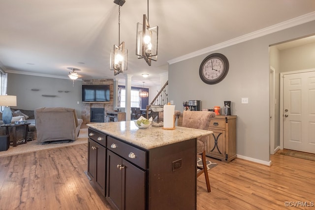 9545 Thornecrest Dr, Mechanicsville, VA 23116 - kitchen with a kitchen bar, light wood-style floors, a stone fireplace, crown molding, and a chandelier