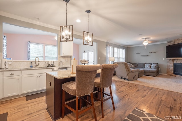 9545 Thornecrest Dr, Mechanicsville, VA 23116 - kitchen featuring crown molding, a kitchen breakfast bar, white cabinets, tasteful backsplash, and light stone countertops