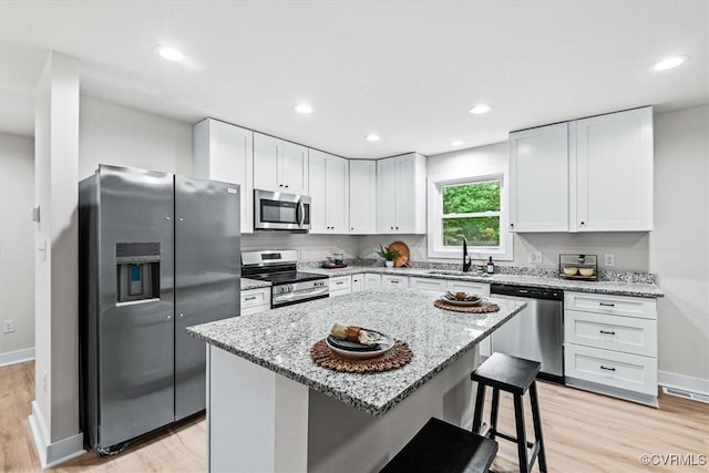 487 Deep Landing Rd, Tappahannock, VA 22560 - kitchen with appliances with stainless steel finishes, light wood-style floors, white cabinets, light stone countertops, and recessed lighting