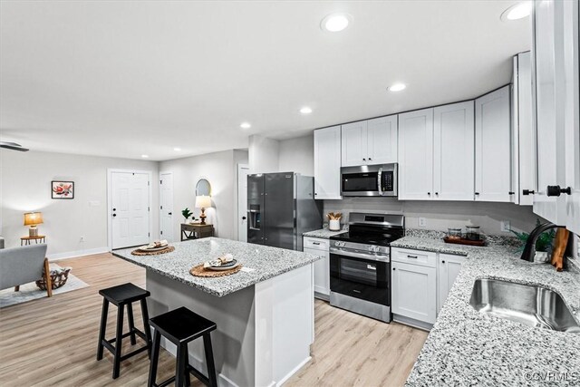 487 Deep Landing Rd, Tappahannock, VA 22560 - kitchen featuring stainless steel appliances, a kitchen island, light wood-style flooring, a kitchen bar, and recessed lighting