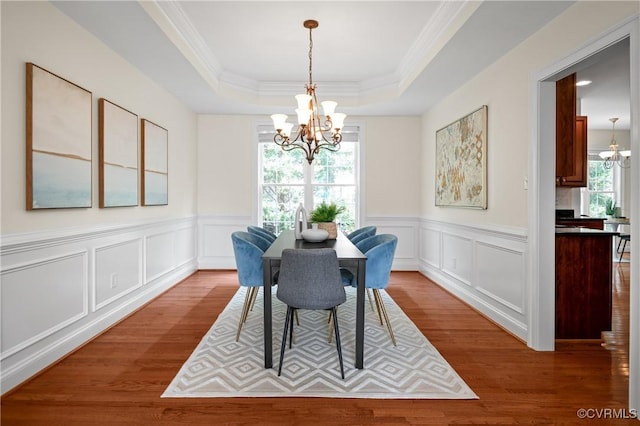 4313 Nevil Bend Turn, Moseley, VA 23120 - dining space with a chandelier, wood finished floors, a tray ceiling, crown molding, and a decorative wall