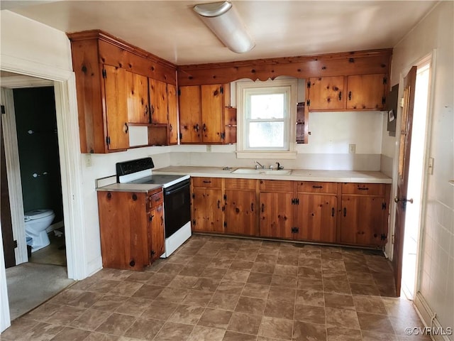 25521 Ferndale Rd, Petersburg, VA 23803 - kitchen with electric stove, brown cabinets, and light countertops