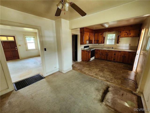 25521 Ferndale Rd, Petersburg, VA 23803 - kitchen with white range with electric cooktop, dark colored carpet, light countertops, ceiling fan, and brown cabinets
