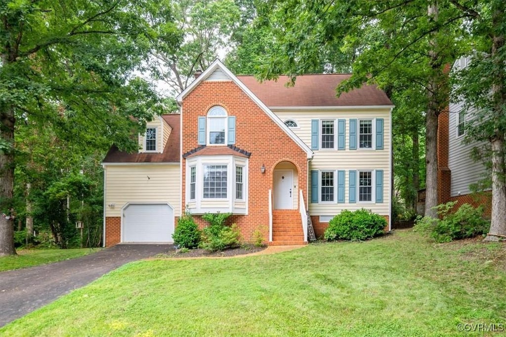 13920 Sandy Oak Rd, Chester, VA 23831 - view of front facade with brick siding, driveway, a front lawn, and an attached garage
