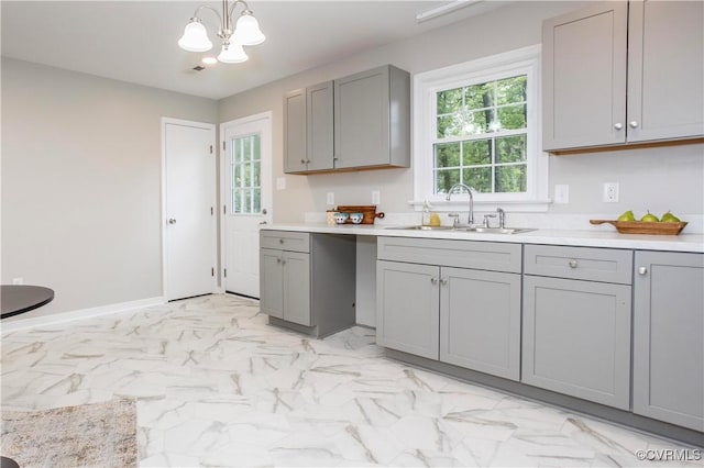 7856 Epic Rd, Midlothian, VA 23235 - kitchen with gray cabinetry, a chandelier, light countertops, light marble finish flooring, and hanging light fixtures