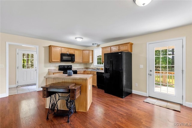 3899 Howell Rd, Powhatan, VA 23139 - kitchen featuring black appliances, light countertops, a center island, and healthy amount of natural light