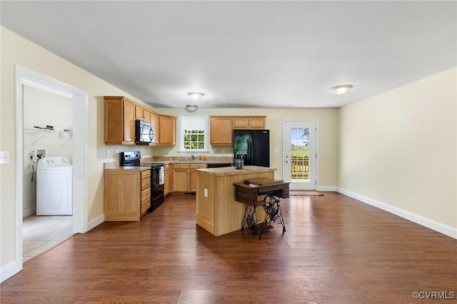 3899 Howell Rd, Powhatan, VA 23139 - kitchen featuring washer / clothes dryer, black appliances, a center island, dark wood finished floors, and a breakfast bar area