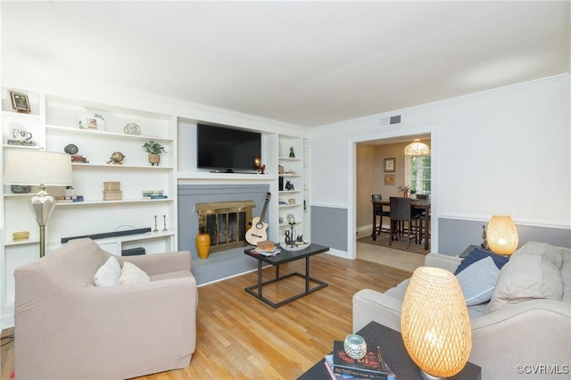 3949 Llewellyn Ln, Chesterfield, VA 23832 - living area with wood finished floors, ornamental molding, built in features, and a brick fireplace