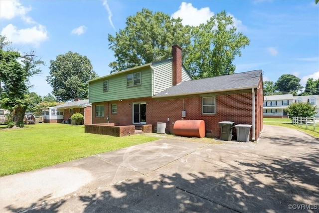 43 Franktown Rd, Hampton, VA 23663 - rear view of property with oil tank, a patio area, a chimney, a lawn, and brick siding