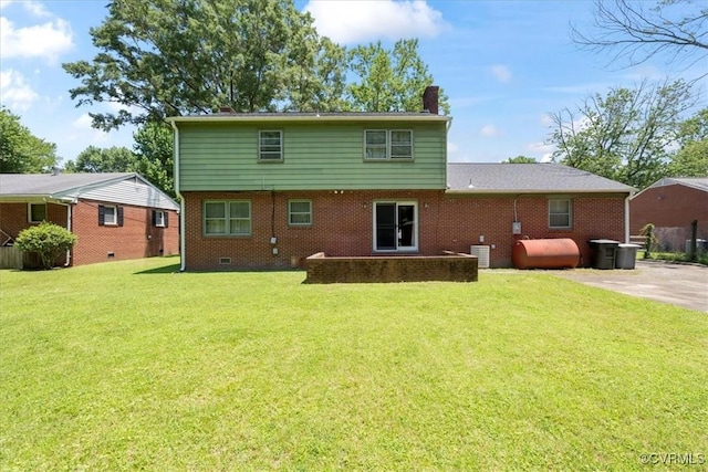 43 Franktown Rd, Hampton, VA 23663 - back of property with oil tank, a chimney, brick siding, and a lawn