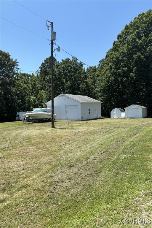 3246 Tabscott Rd, Goochland, VA 23038 - view of green lawn with an outdoor structure, a forest view, and a detached garage