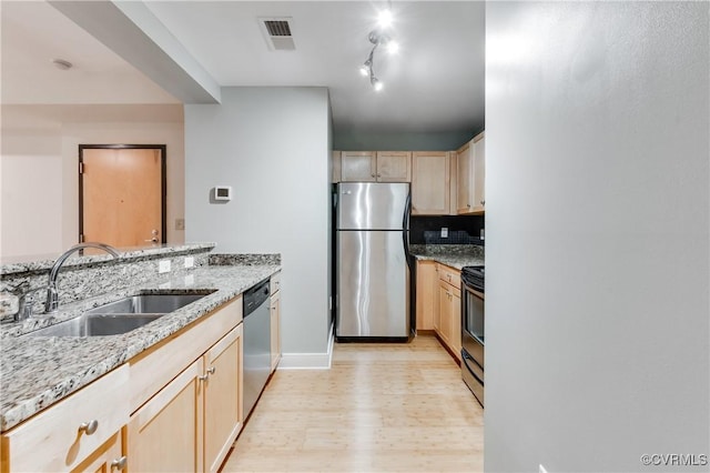 110 W Marshall St Unit U25, Richmond, VA 23220 - kitchen with appliances with stainless steel finishes, light brown cabinetry, light wood-style flooring, light stone countertops, and decorative backsplash