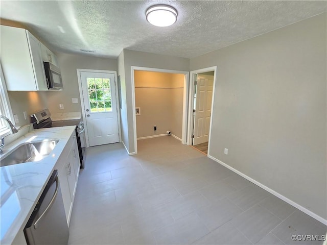 5102 Randall Ave, Henrico, VA 23231 - kitchen with stainless steel appliances, white cabinets, a textured ceiling, and light stone countertops
