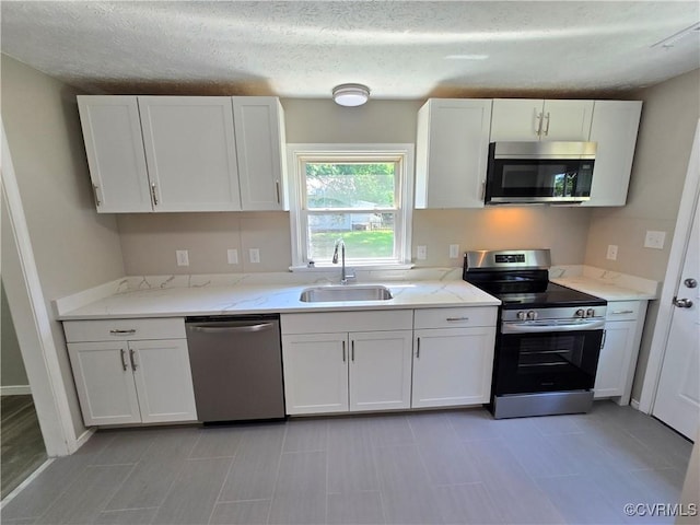 5102 Randall Ave, Henrico, VA 23231 - kitchen featuring stainless steel appliances, white cabinetry, a textured ceiling, and light stone countertops